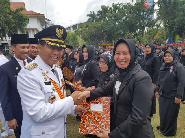 Kepala SMK Hasanah, Sondang Elisabet, menerima sertifikat penghargaan Sekolah Adiwiyata tingkat Kota Pekanbaru, dari Walikota Pekanbaru, Firdaus MT, saat upacara HUT ke-71 RI, Rabu (17/8/2016).IST